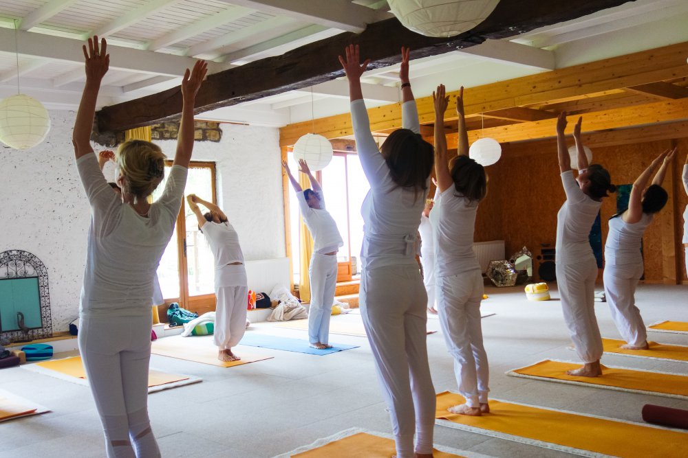 Yoga-Teilnehmerinnen in entspannter Haltung während eines Hatha-Yoga-Retreats mit Claudia Zingraf – Achtsamkeit, Ruhe und sanfte Dehnung.