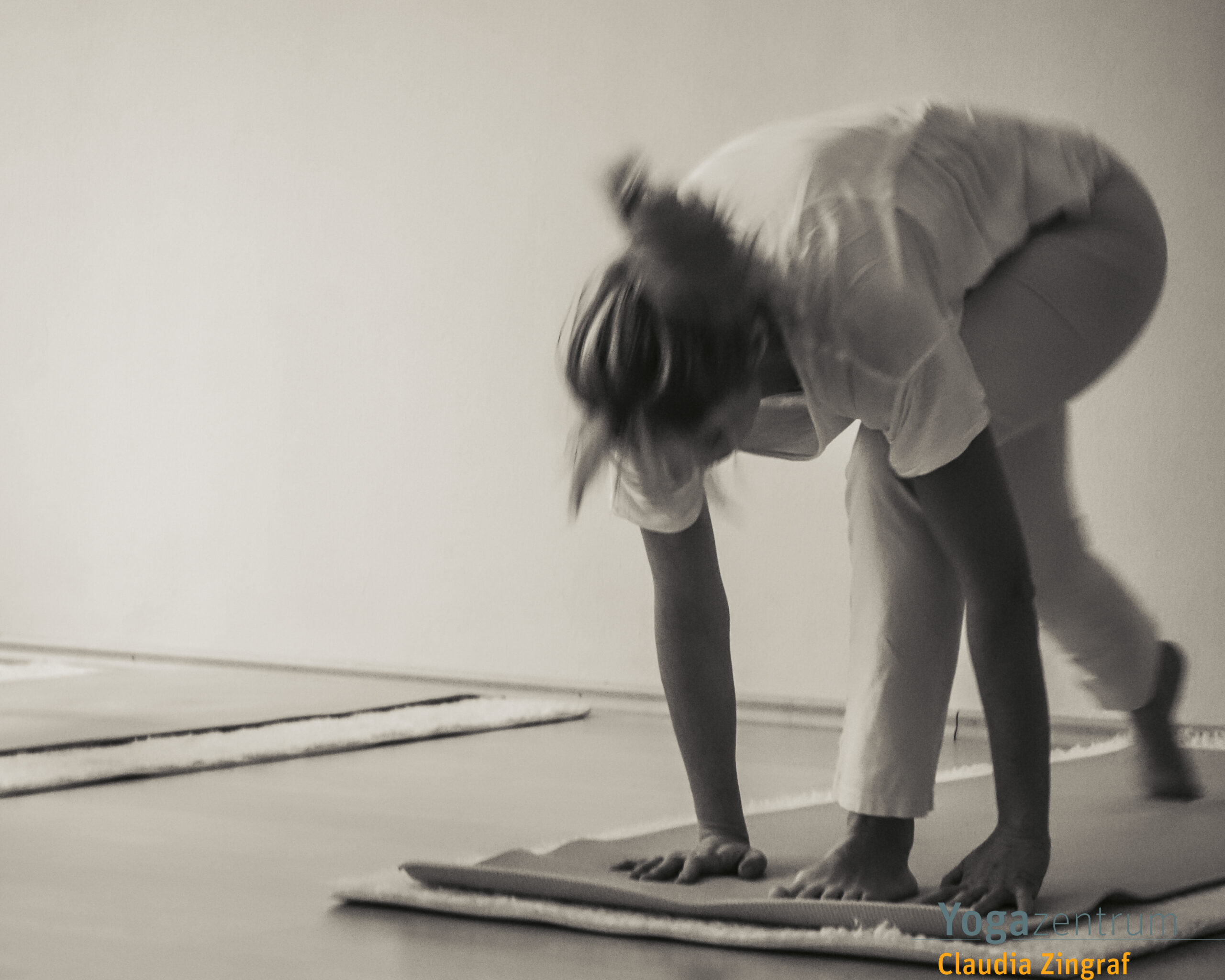 Frau in dynamischer Yoga-Bewegung während einer Hatha-Yoga-Stunde bei Claudia Zingraf in Saarbrücken – achtsamer Übergang im Sonnengruß.