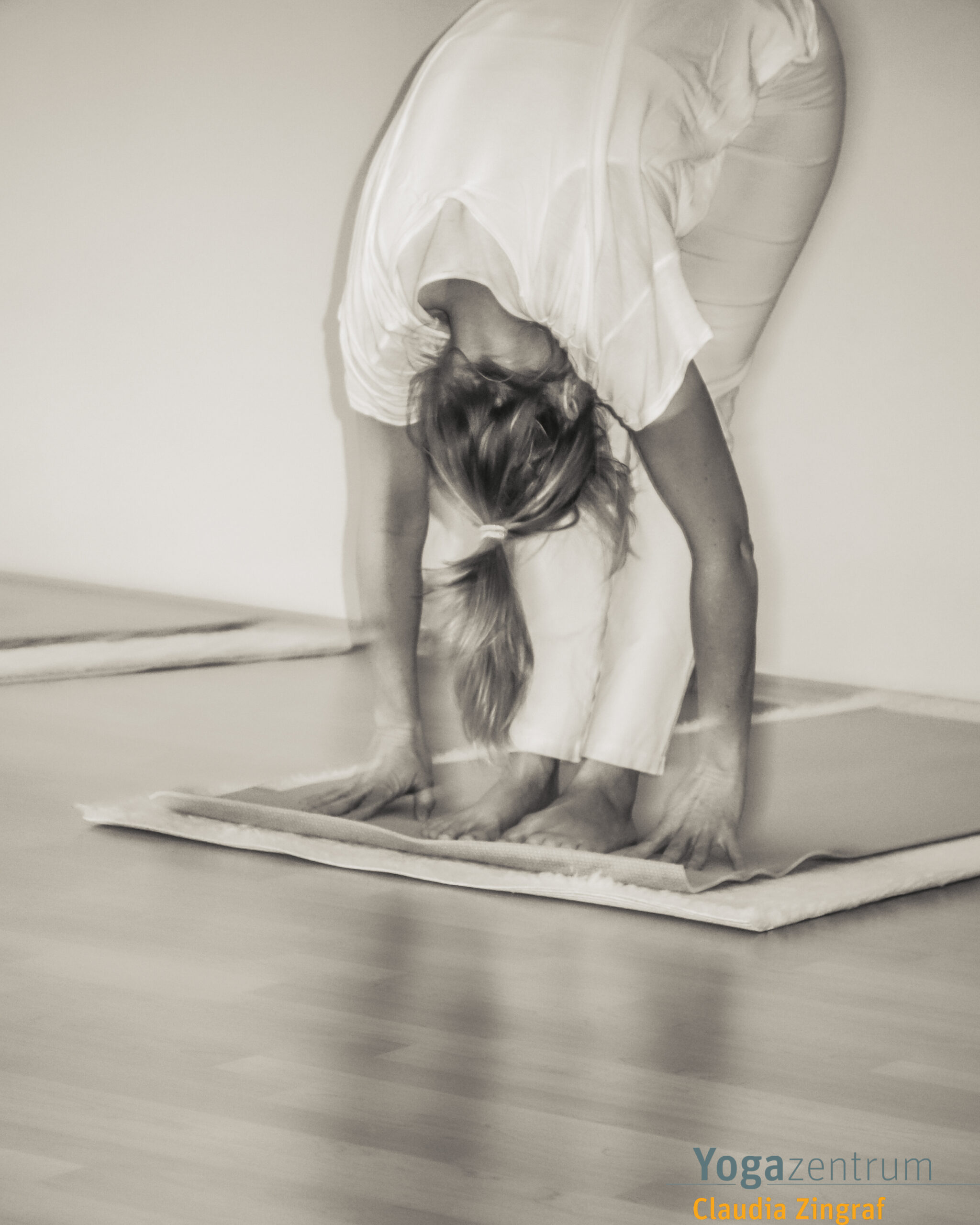 Frau in der Yoga-Vorwärtsbeuge (Uttanasana) im Hatha-Yoga-Unterricht bei Claudia Zingraf in Saarbrücken – achtsame Dehnung und Ruhe.