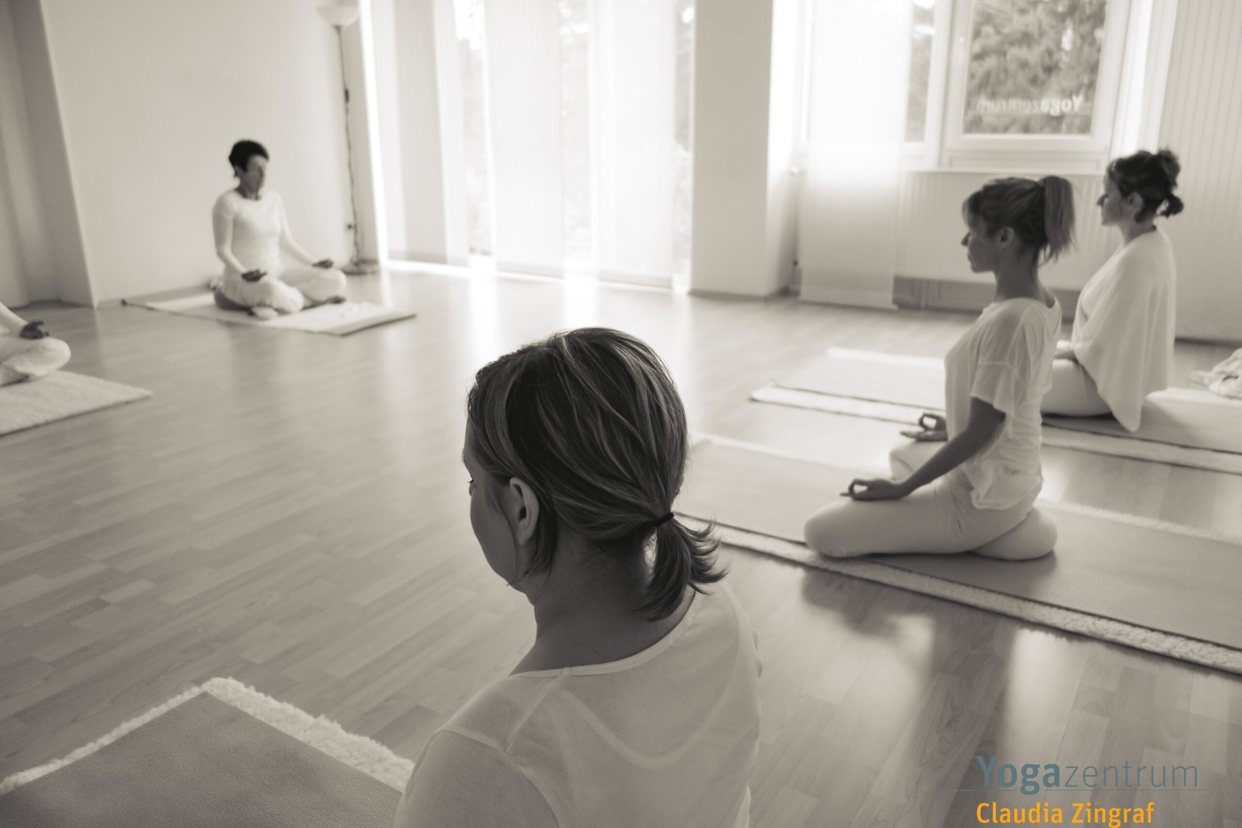 Yoga-Teilnehmer in aufrechter Meditationshaltung während einer Hatha-Yoga-Stunde bei Claudia Zingraf in Saarbrücken – achtsame Stille und Präsenz.